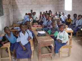 children sitting four to a desk at Abuko school