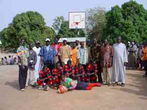 Bakalarr football team members in their new kit with teachers on the multi-purpose court