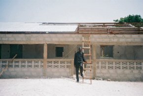 Bakary standing in front of the new building