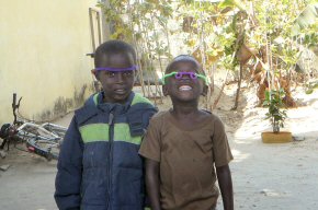 Some children at a compound wearing pipecleaner glasses made by Abdoulie