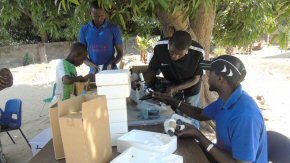 Inspecting the microscopes for termite damage at Wandifa's compound