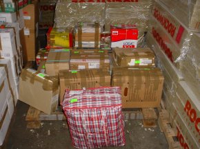 cardboard boxes and other packages stacked ready to be loaded into a container in the UK