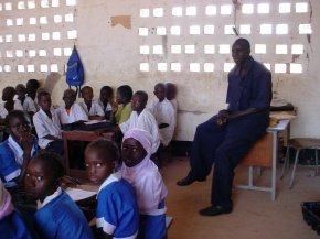 another part of the classroom with children and the teacher showing the sandy floor