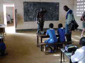 Kemo watches a class in progress in one of the classrooms with a new concrete floor