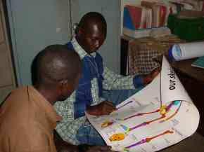 Kemo and the School Charirman look at an anatomical poster