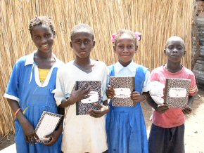 children with their gifts of exercise books