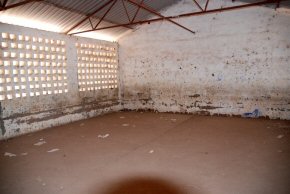 One of the classrooms with no furniture and cracked floor and damaged walls