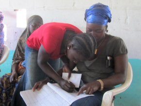 Isatou Susso signing Tombong's book 