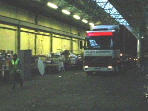 an articulated truck with container on board driving into the warehouse where packing is to take place