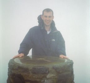 Chris posing by the trignometry point at the top of Snowdon