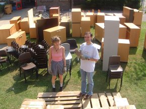 furniture stacked on the grass waiting to be loaded