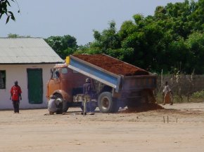 a tipper lorry dumps a load of gravel for the new concrete multipurpose court