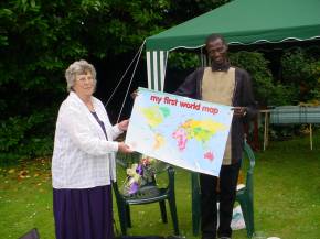 Diana gives Bakary a World Map for the classroom wall