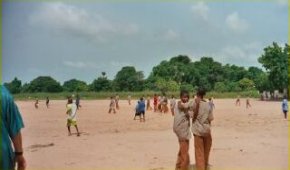 the school grounds with children playing on a large sandy area