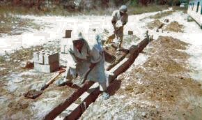 the foundation courses of  in the trenches sand is unloaded from a small trailer