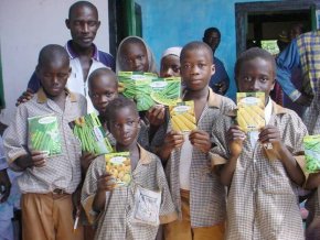 a group of school students hold up packets of seeds donated by Unwins and Suttons