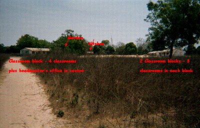 view of Bakalarr school in 2000 showing the dirt road and clasroom blocks surounded by unfenced scrub