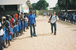 Dave and Alimatou walking in behind the car