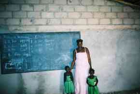 a techer and two children inside the partrly refurbished classroom