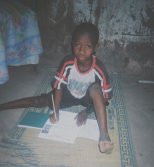 a boy squats in the ground with his sponsorship form