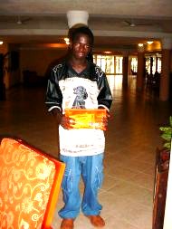 Alieu can now progress to Further Education, and poses with his sponsorship documents