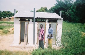 the toilet block has been completed, painted white and finished with doors and a corrugated iron roof