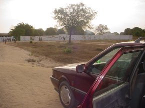 view of Bakalarr school from the approach road showing the boundary wall surrounding the school grounds